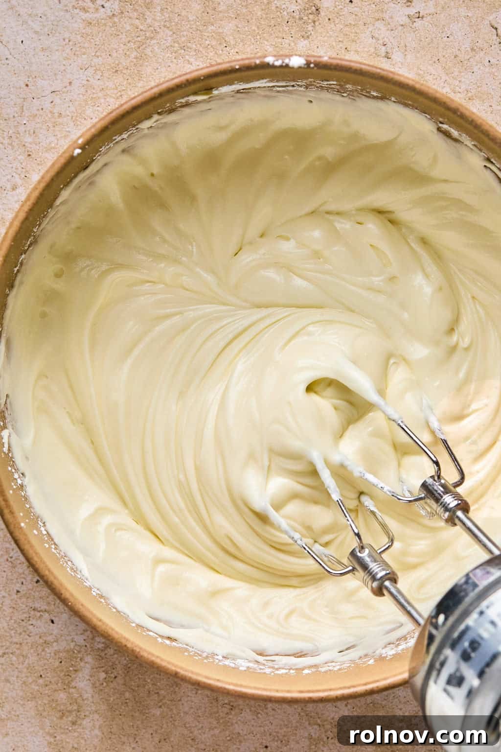 Golden Spiced Molasses Pumpkin Chews 14 Maple cream cheese frosting in mixing bowl with electric mixer.