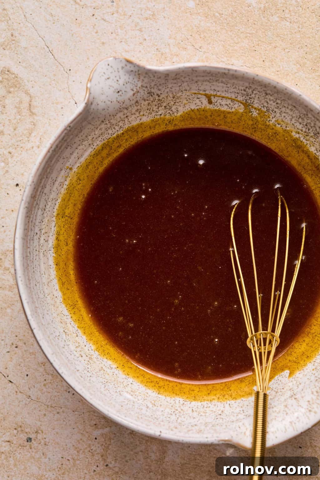 Golden Spiced Molasses Pumpkin Chews 5 Whisked molasses cookie wet ingredients with whisk propped in it.