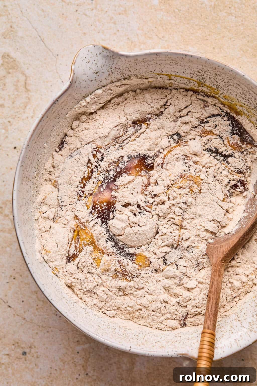 Golden Spiced Molasses Pumpkin Chews 7 Dry and wet ingredients for pumpkin molasses cookies being combined in bowl.