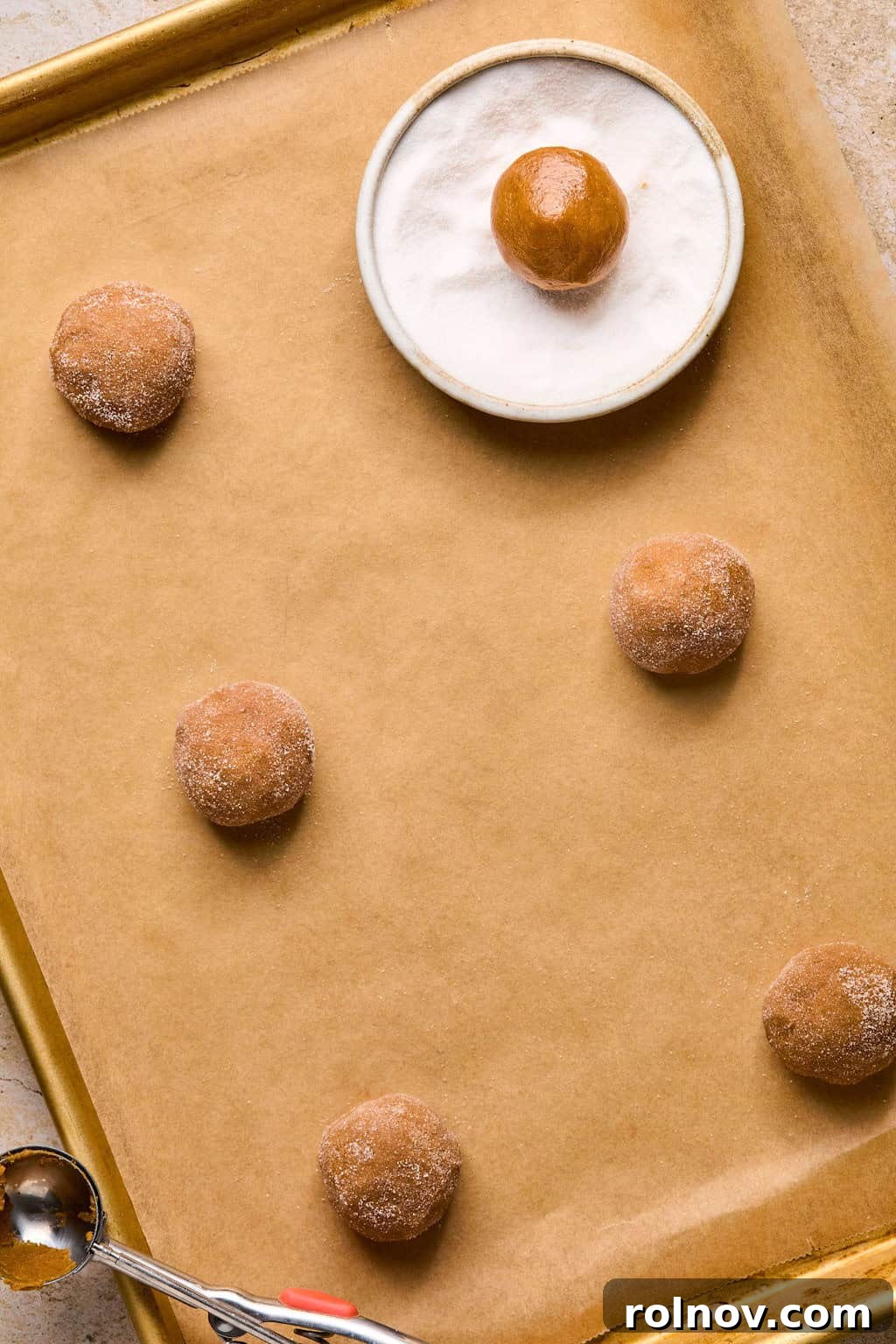 Golden Spiced Molasses Pumpkin Chews 9 Rolled pumpkin spice cookies on parchment before baking.