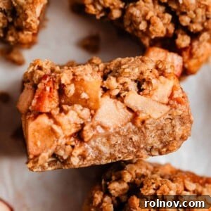 Apple crumble bar propped on surrounding sliced bars.
