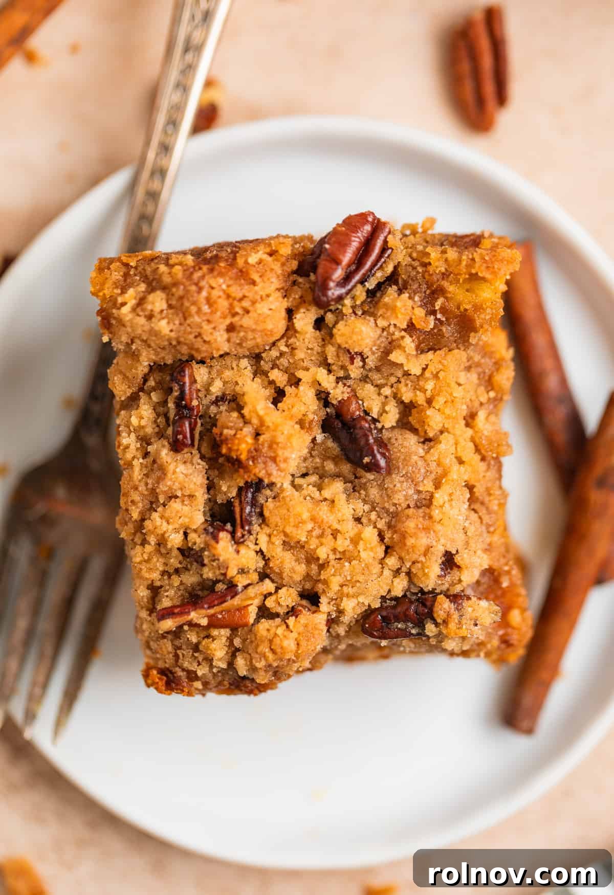Pumpkin Spice French Toast Bake 11 Slice of streusel topped pumpkin baked french toast on white dish with fork.
