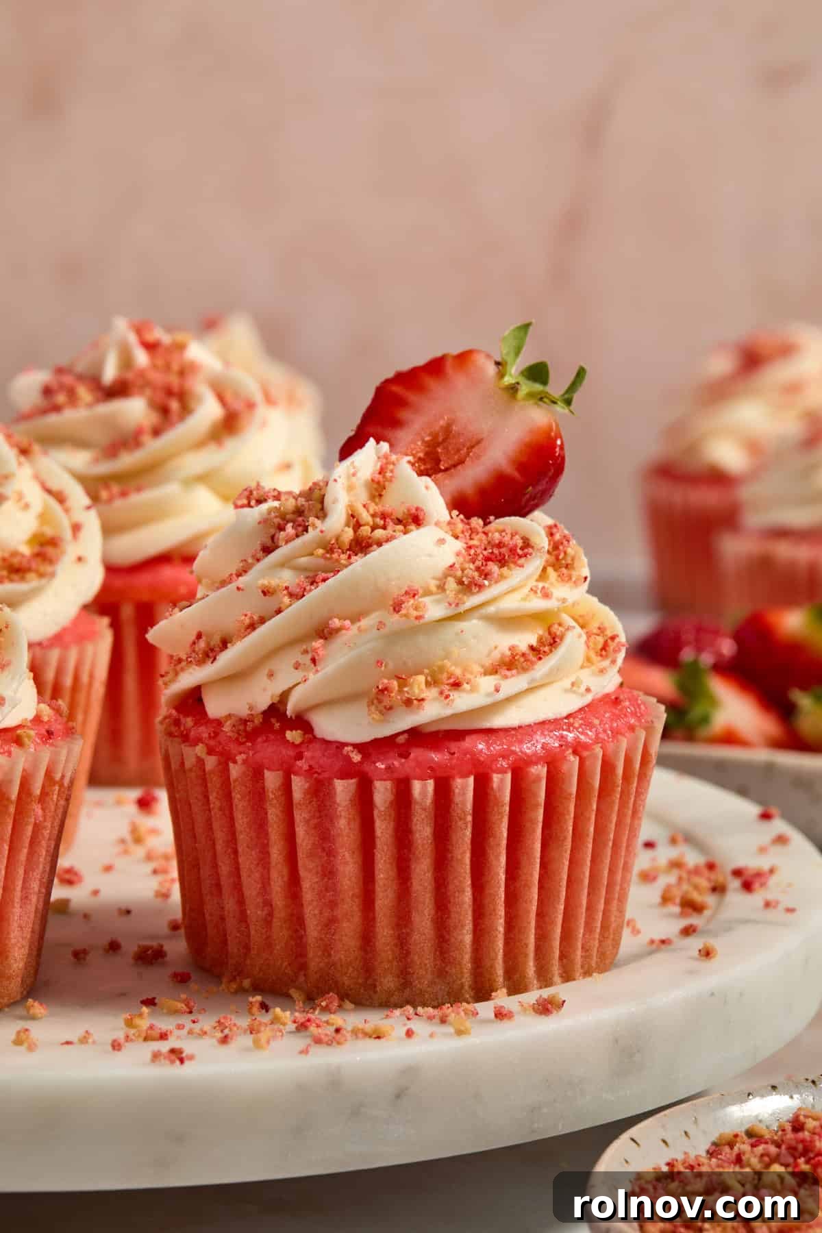 Berry Crunch Bliss Cupcakes 2 Strawberry crunch cupcakes topped with strawberry slice for garnish, looking incredibly delicious.