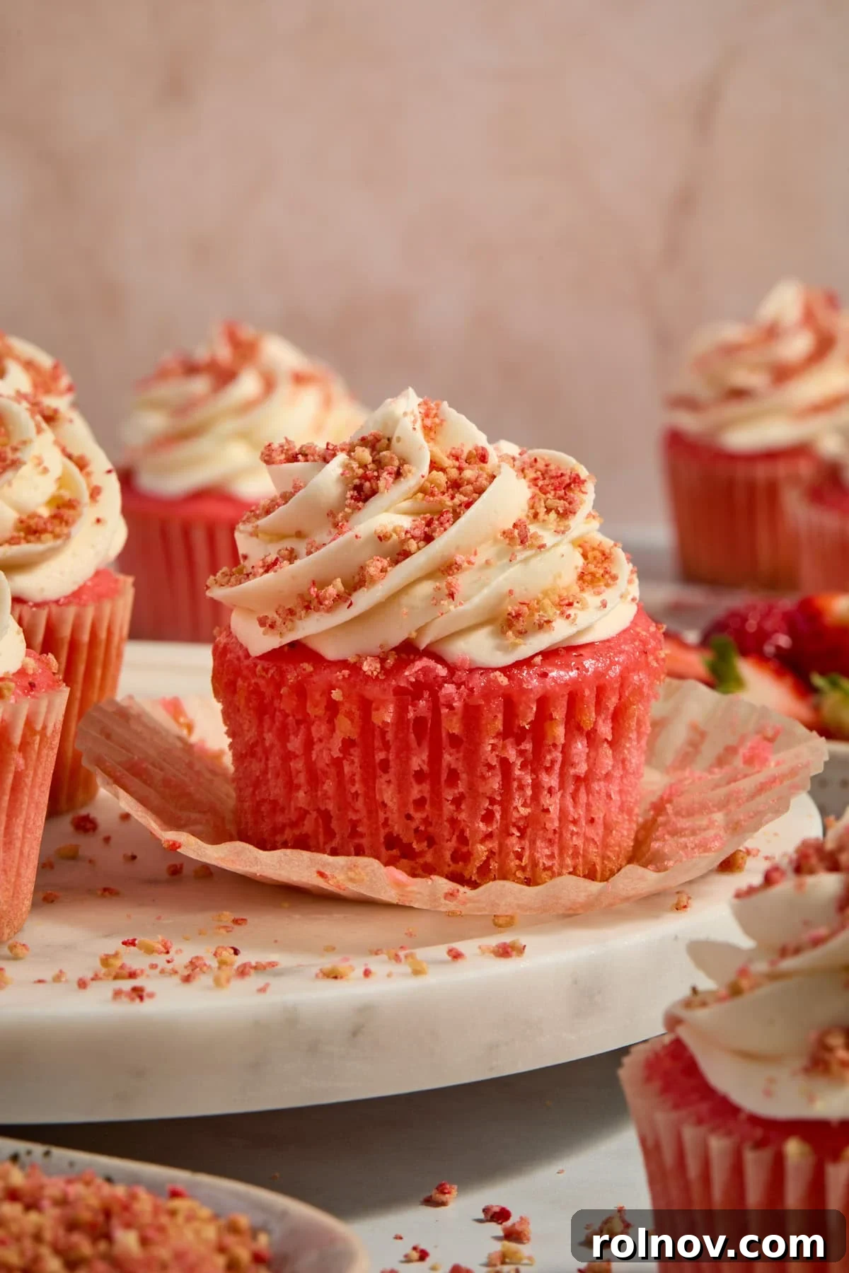 Berry Crunch Bliss Cupcakes 13 Close-up of strawberry crunch cupcakes arranged on a tray, with one liner pulled down to show the moist cake texture.