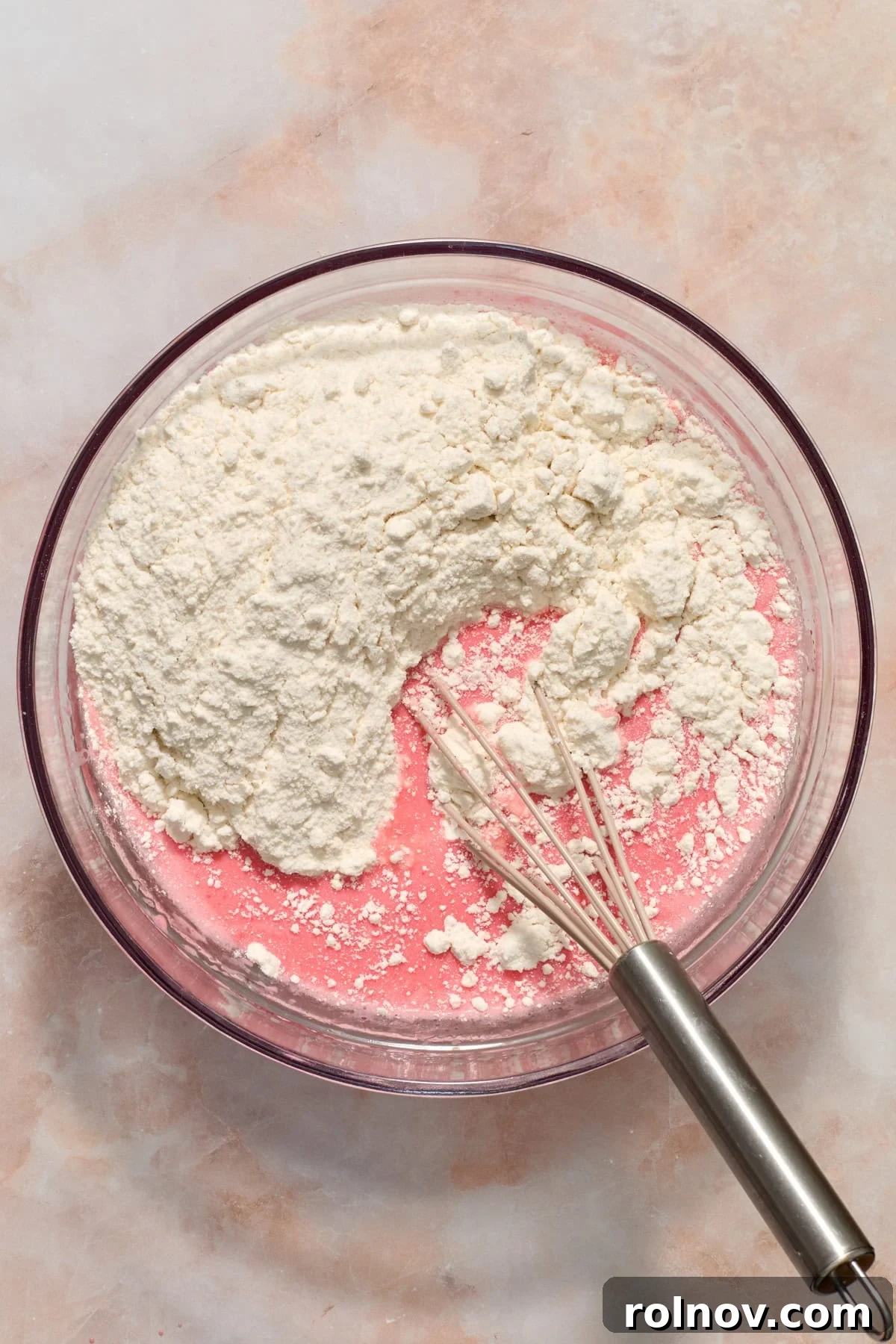 Berry Crunch Bliss Cupcakes 5 White cake mix being added to the bowl with whisked wet ingredients.