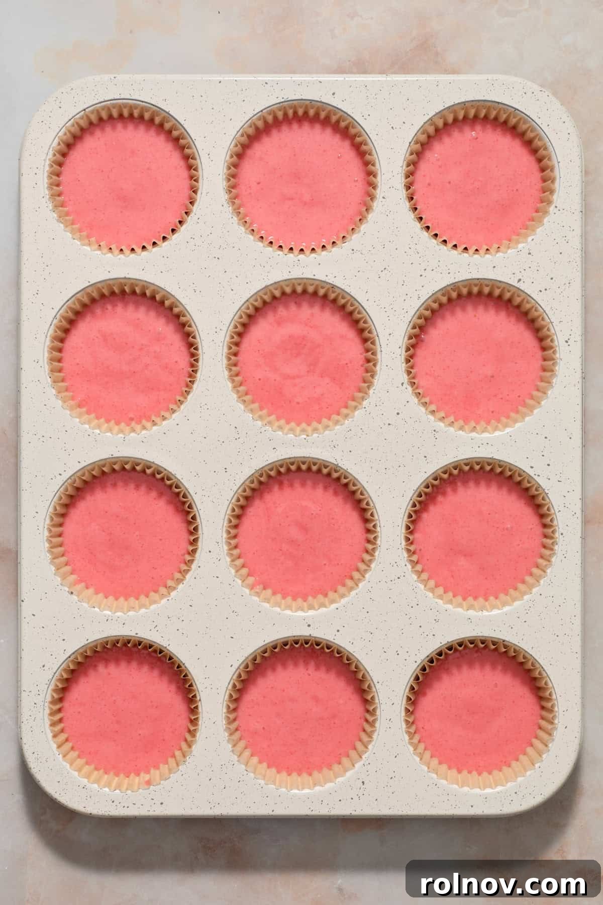 Berry Crunch Bliss Cupcakes 6 Cupcake liners filled with strawberry cupcake batter, ready for baking.