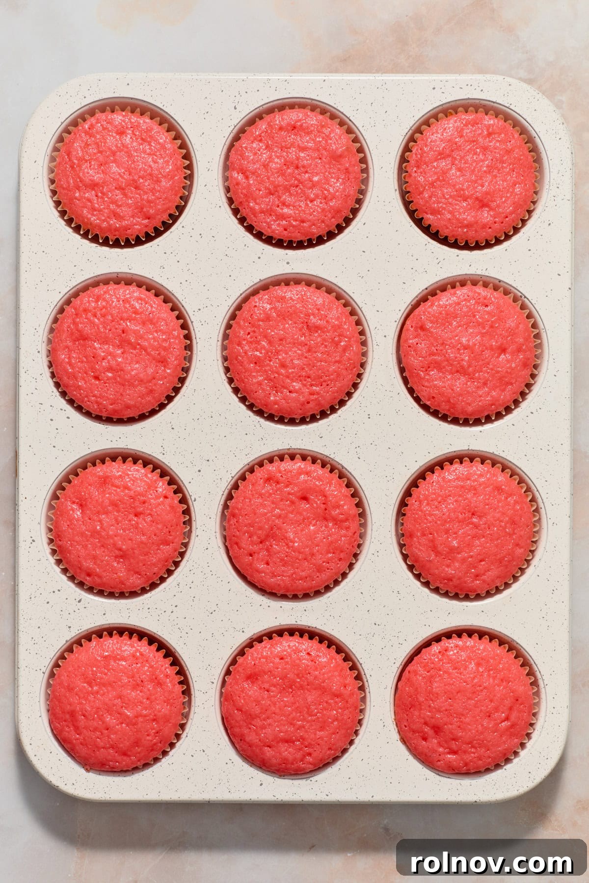 Berry Crunch Bliss Cupcakes 7 Freshly baked strawberry cupcakes cooling in a muffin tin.