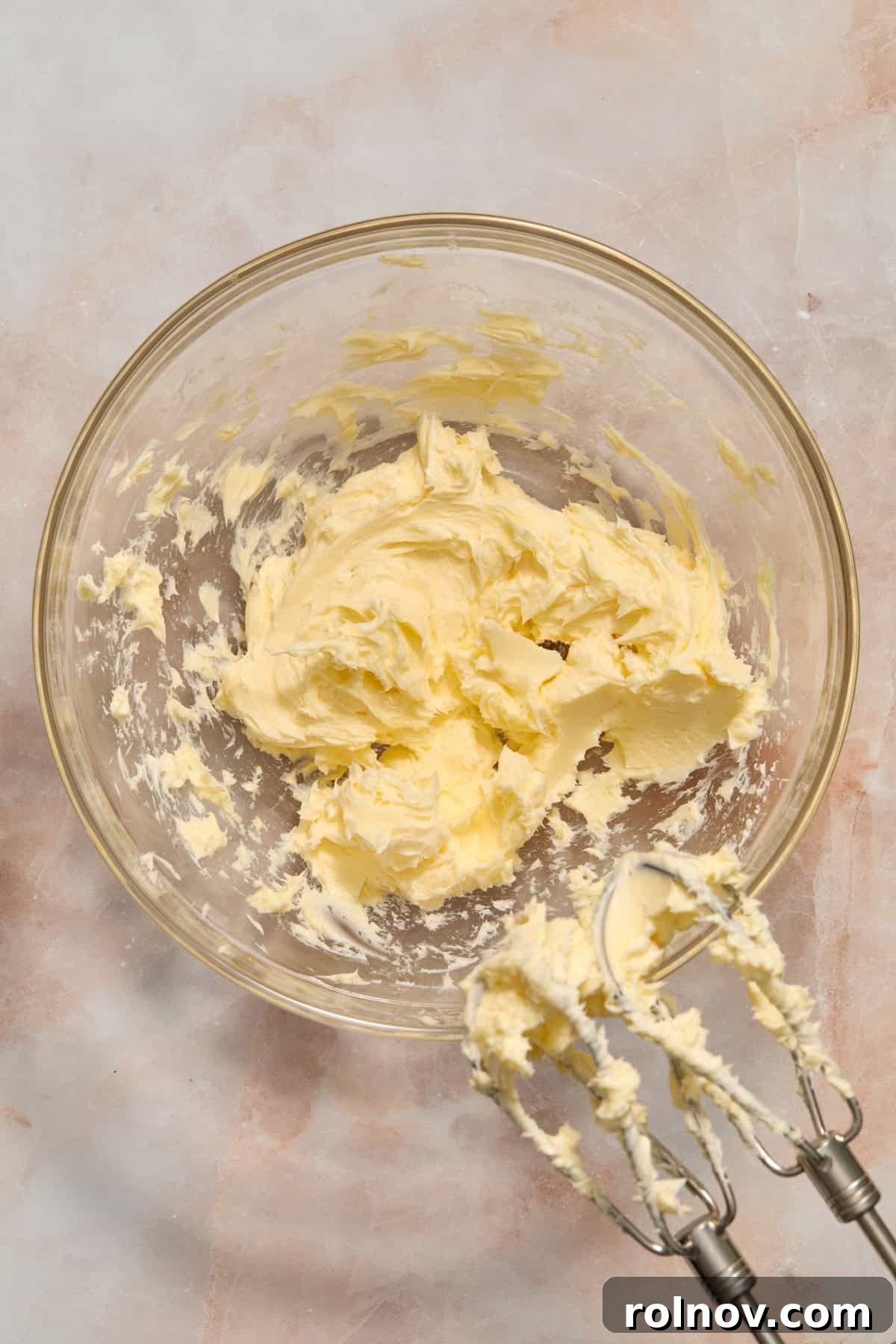 Berry Crunch Bliss Cupcakes 8 Creamed softened butter in a glass bowl with an electric hand mixer nearby.