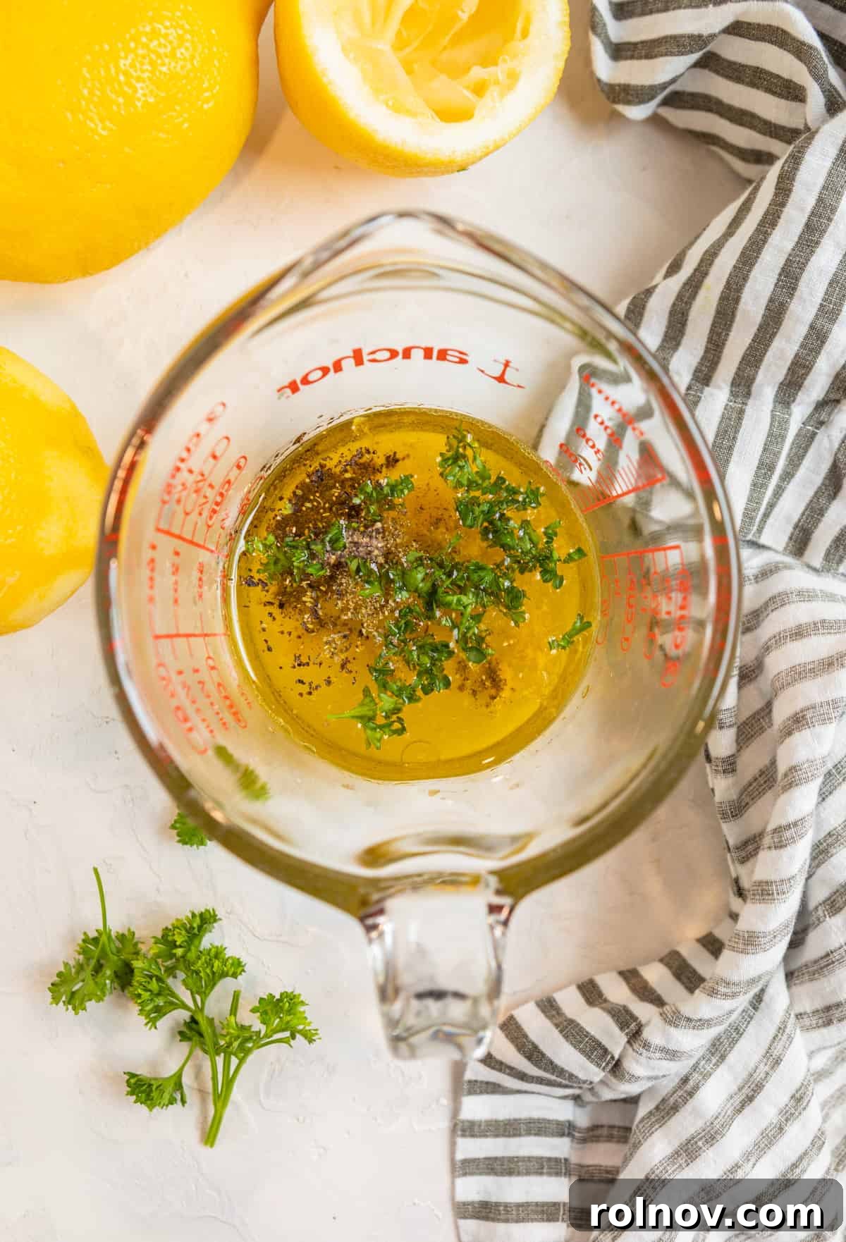 Measuring cup with honey lemon dijon dressing ingredients before whisking.