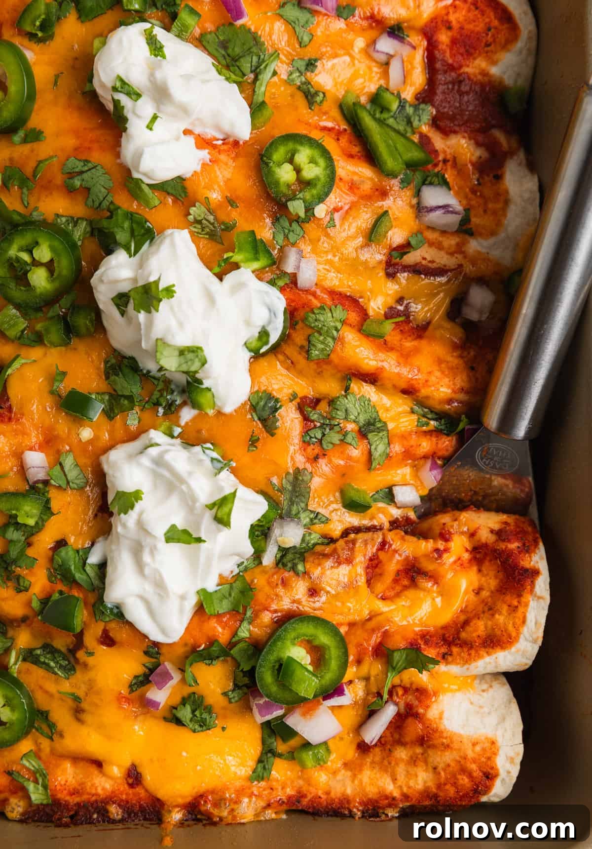 Ground turkey enchiladas in pan topped with cheese, jalapeños, cilantro and more.