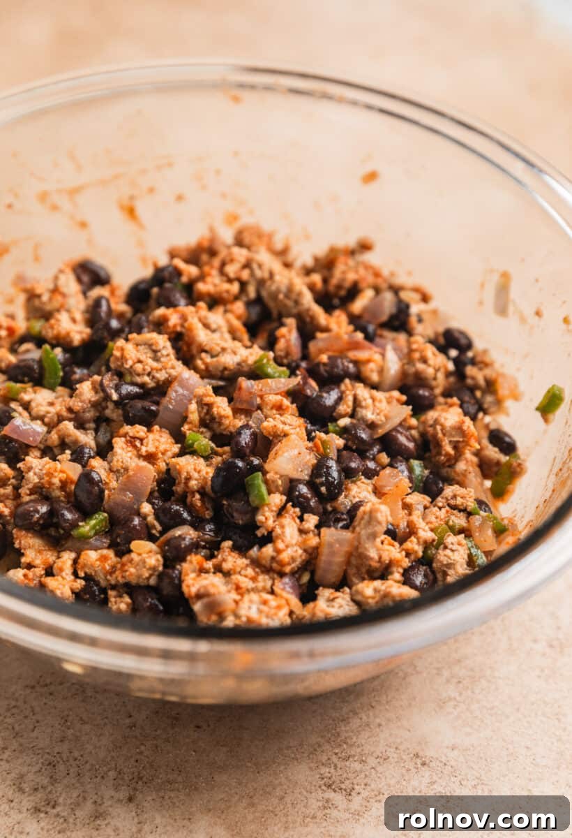 Ground turkey black bean mixture in glass mixing bowl.