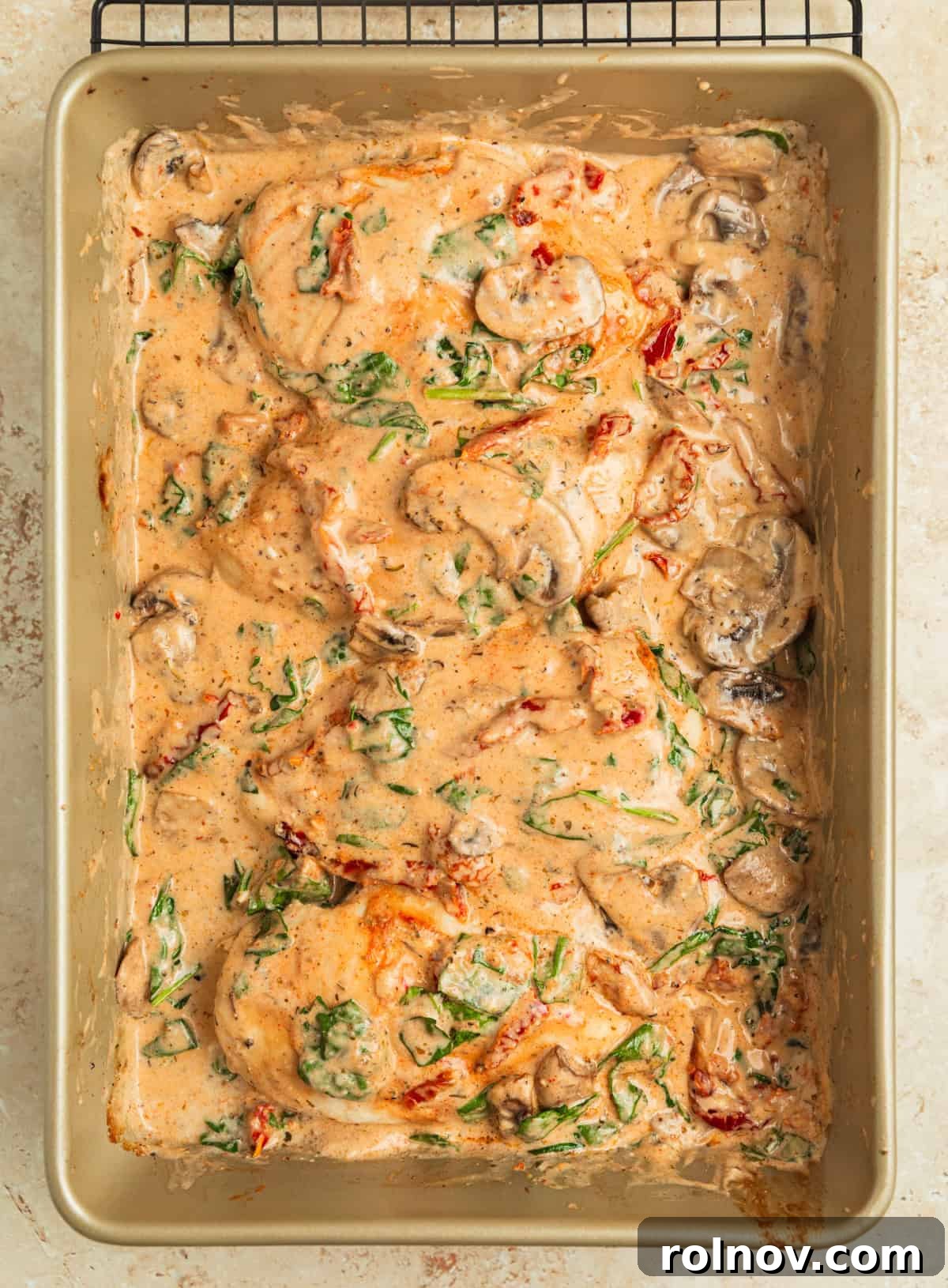 Savory Tuscan Chicken Bake 11 The finished Baked Tuscan Chicken in the pan, with wilted spinach, creamy sauce, and perfectly cooked chicken, garnished and ready to serve.