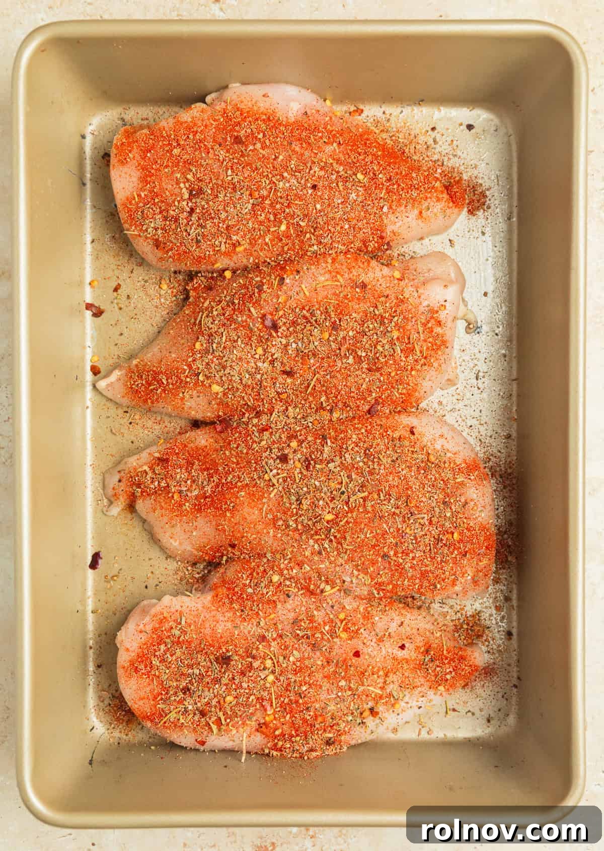 Savory Tuscan Chicken Bake 4 Seasoned chicken breasts lined in a glass baking pan, ready for the sauce and baking.