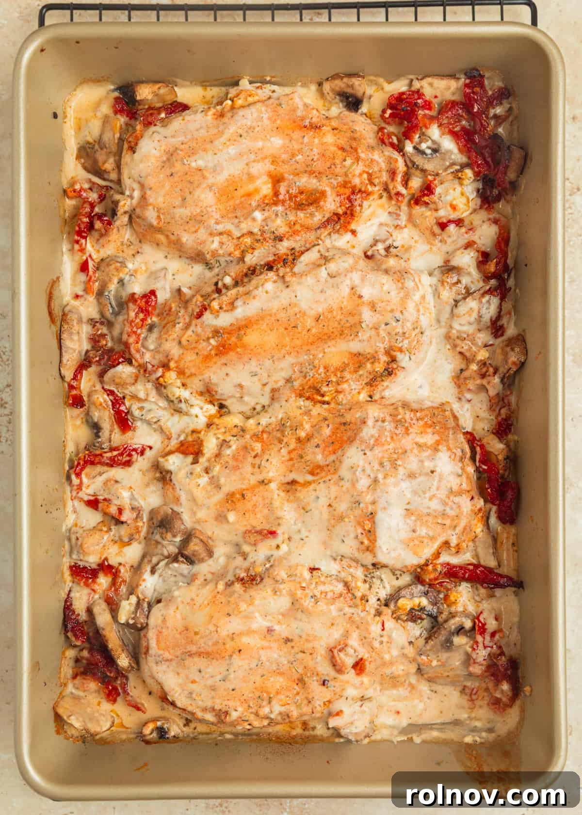 Savory Tuscan Chicken Bake 9 Freshly baked Tuscan chicken in the pan, golden and bubbling, with a rich creamy sauce over top, ready for the final step.