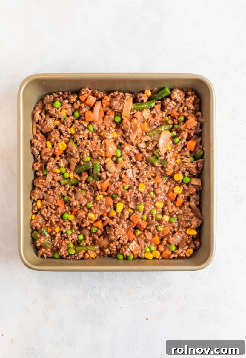 Beef and vegetable mixture in baking pan.