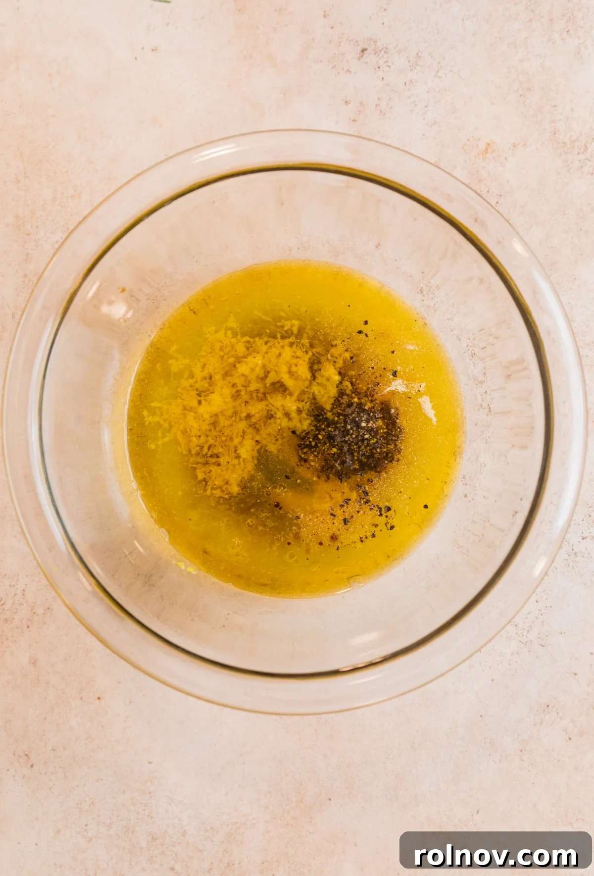 Zesty Lemon Pepper Pork Chops 4 All the lemon pepper marinade ingredients, including fresh lemon, olive oil, and spices, gathered in a glass mixing bowl, ready to be combined.