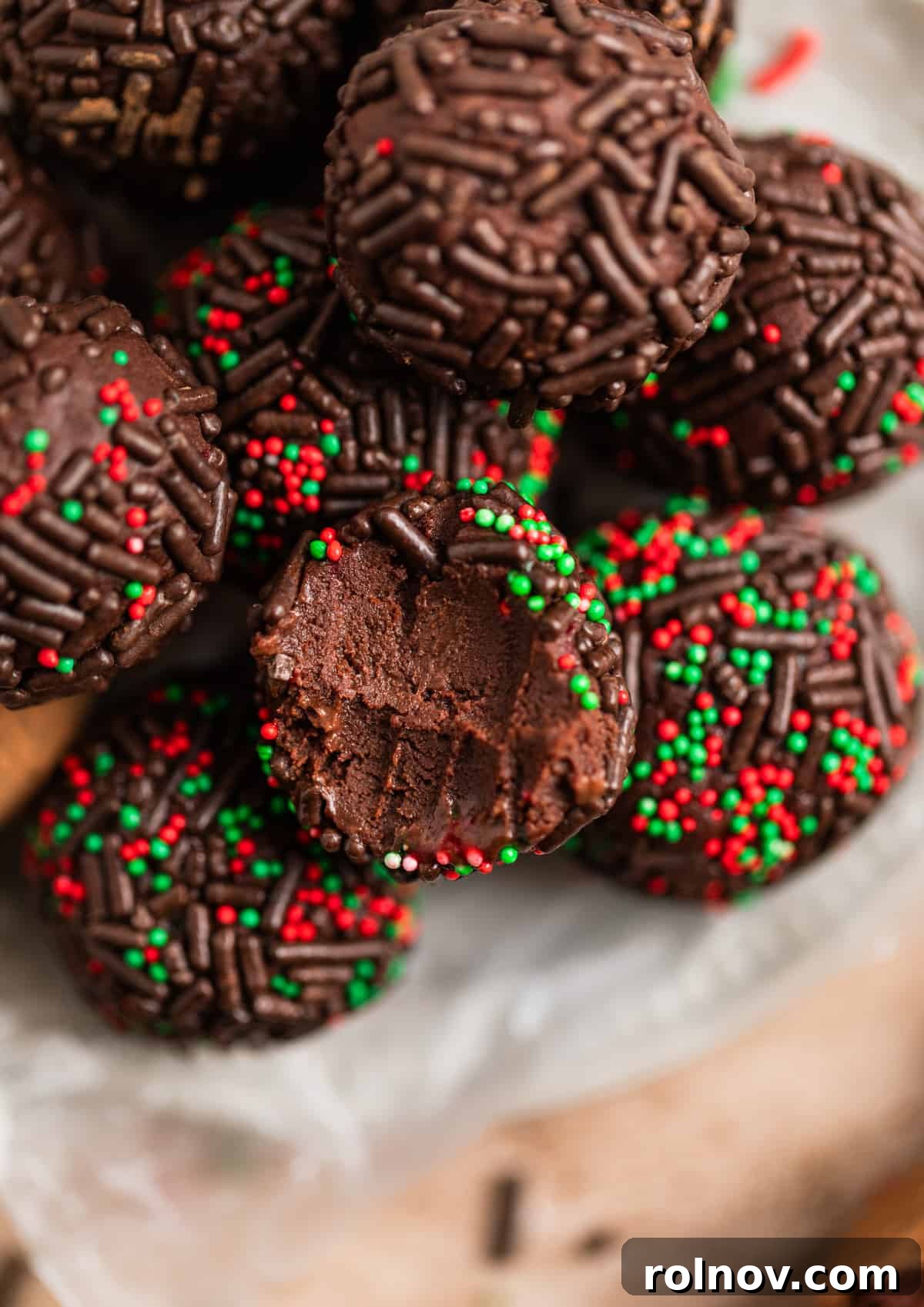 Effortless 5 Ingredient Amaretto Truffles 3 Chocolate, red and green sprinkle covered amaretto truffles arranged on dish.
