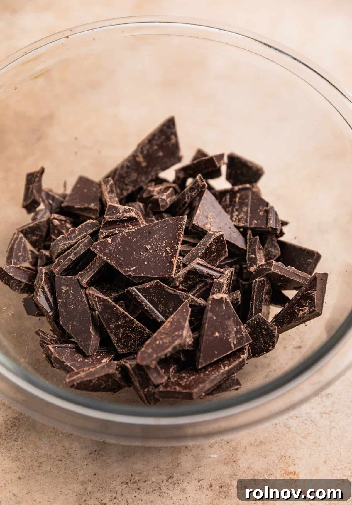 Effortless 5 Ingredient Amaretto Truffles 4 Chopped dark chocolate in glass bowl.