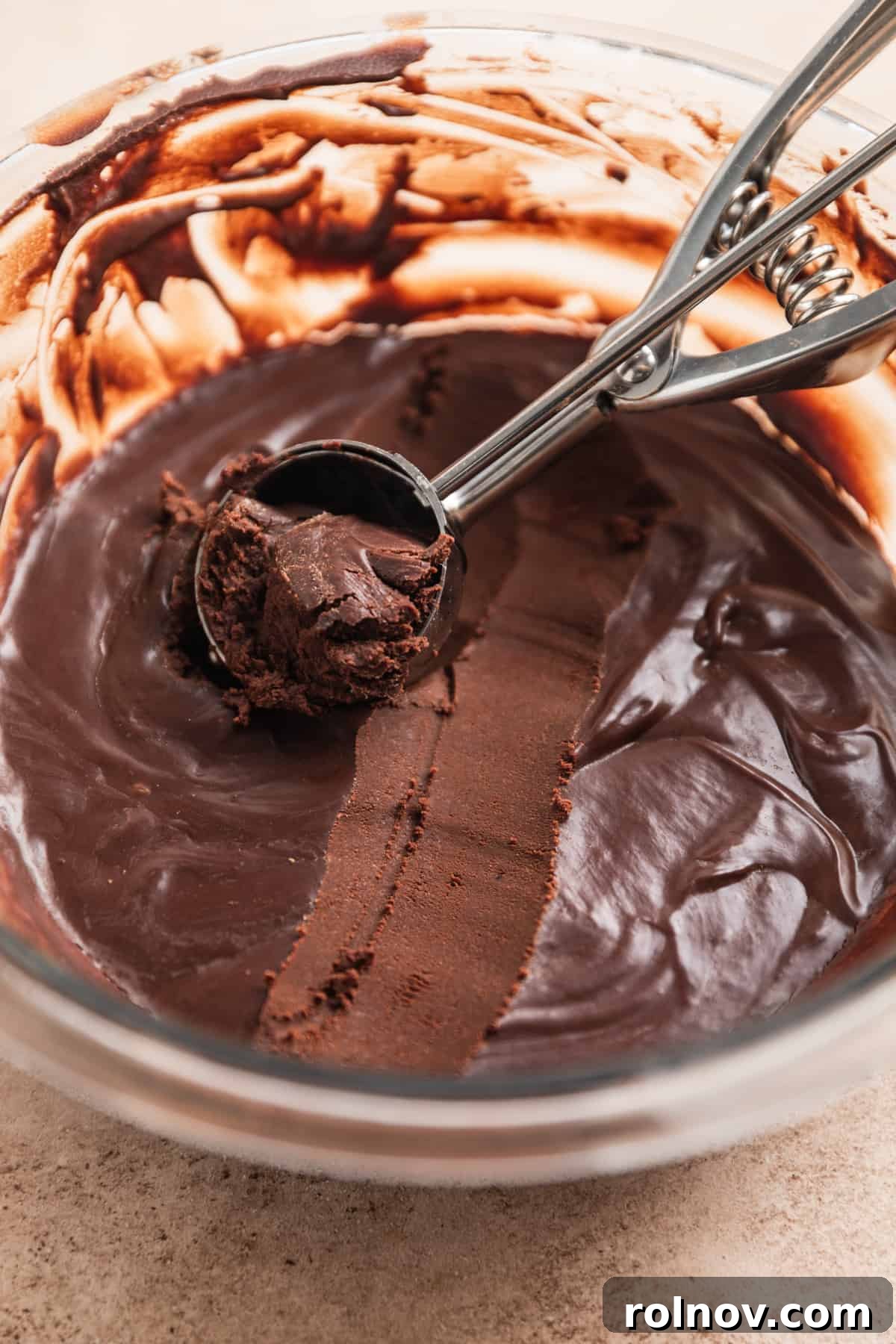 Effortless 5 Ingredient Amaretto Truffles 8 Cookie scoop with chocolate truffle mixture scooped.