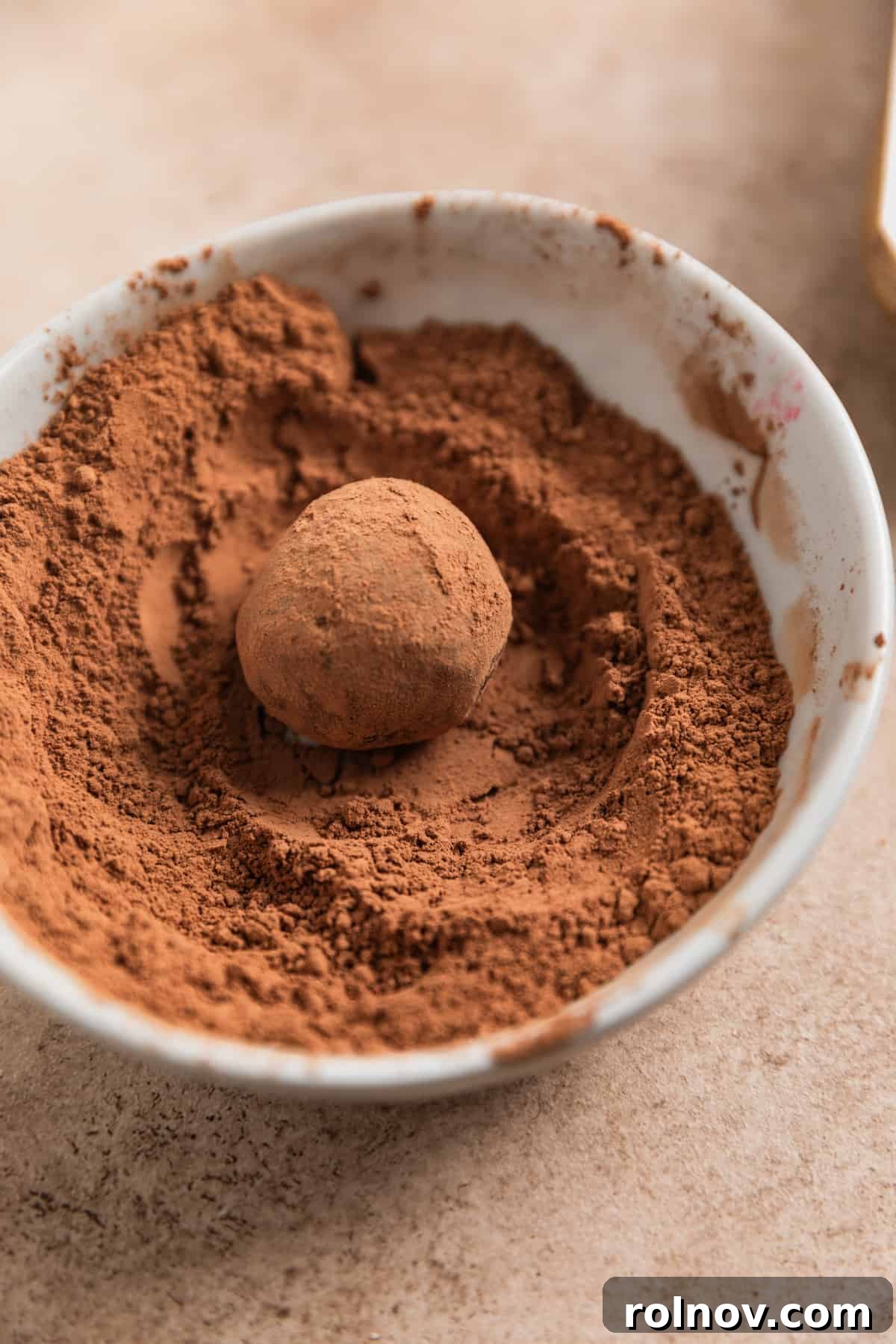Effortless 5 Ingredient Amaretto Truffles 10 Amaretto truffle in bowl with cocoa powder.