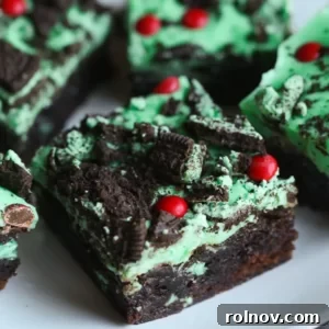Green mint-iced Grinch Brownies, topped with crushed Oreos and red candies.