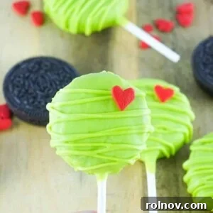 Whimsical Grinch Oreo Pops, coated in green chocolate with a red heart.