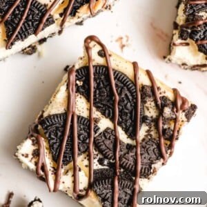 Oreo Cheesecake Bars, neatly sliced and drizzled with rich chocolate sauce.
