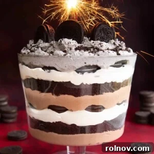 An indulgent Oreo Trifle served in a clear trifle dish, showing layers of Oreos, cream, and chocolate pudding.