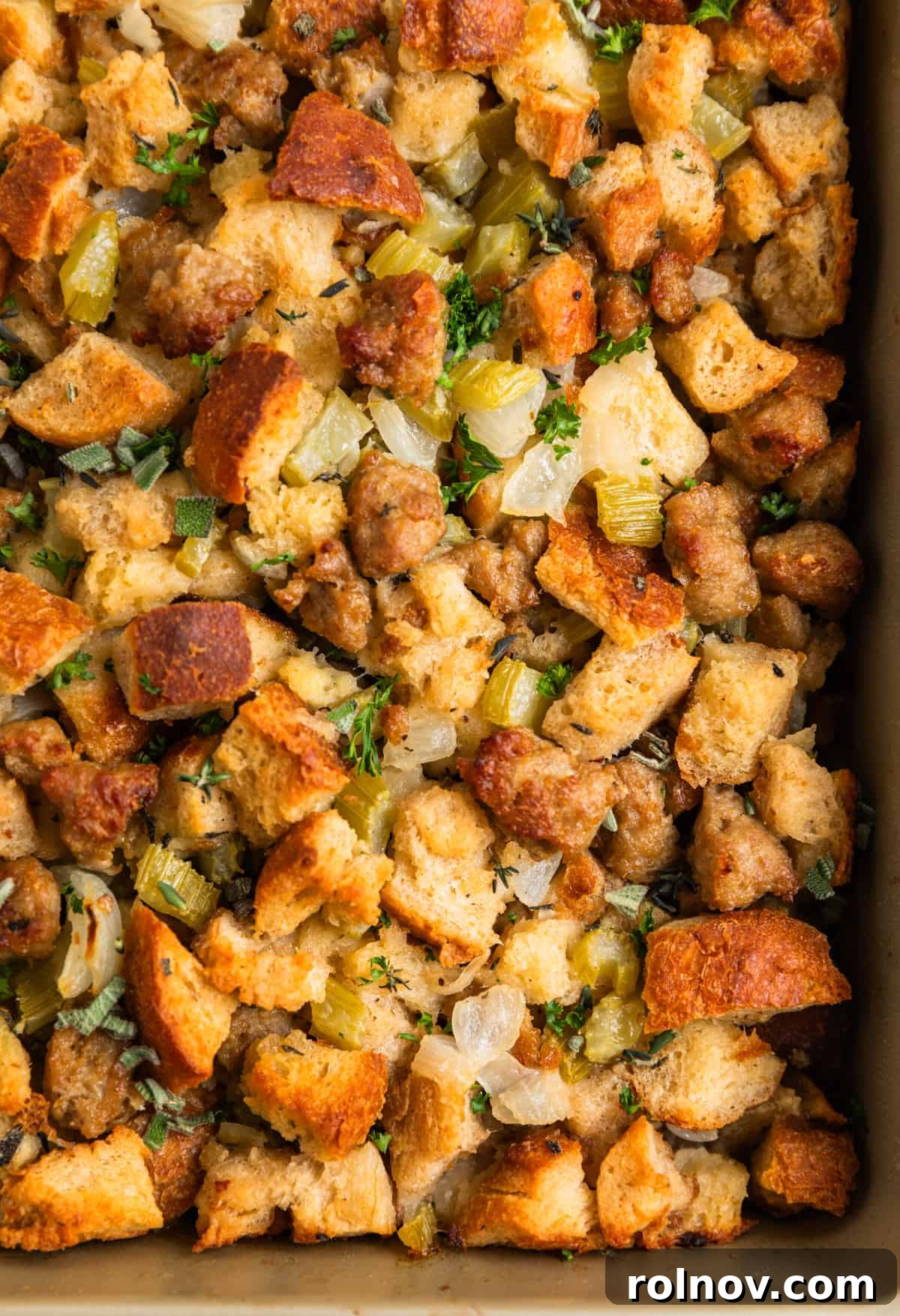 Classic Turkey Sausage Dressing 2 Pan with turkey sausage stuffing baked and topped with freshly chopped parsley and thyme, ready to be served.