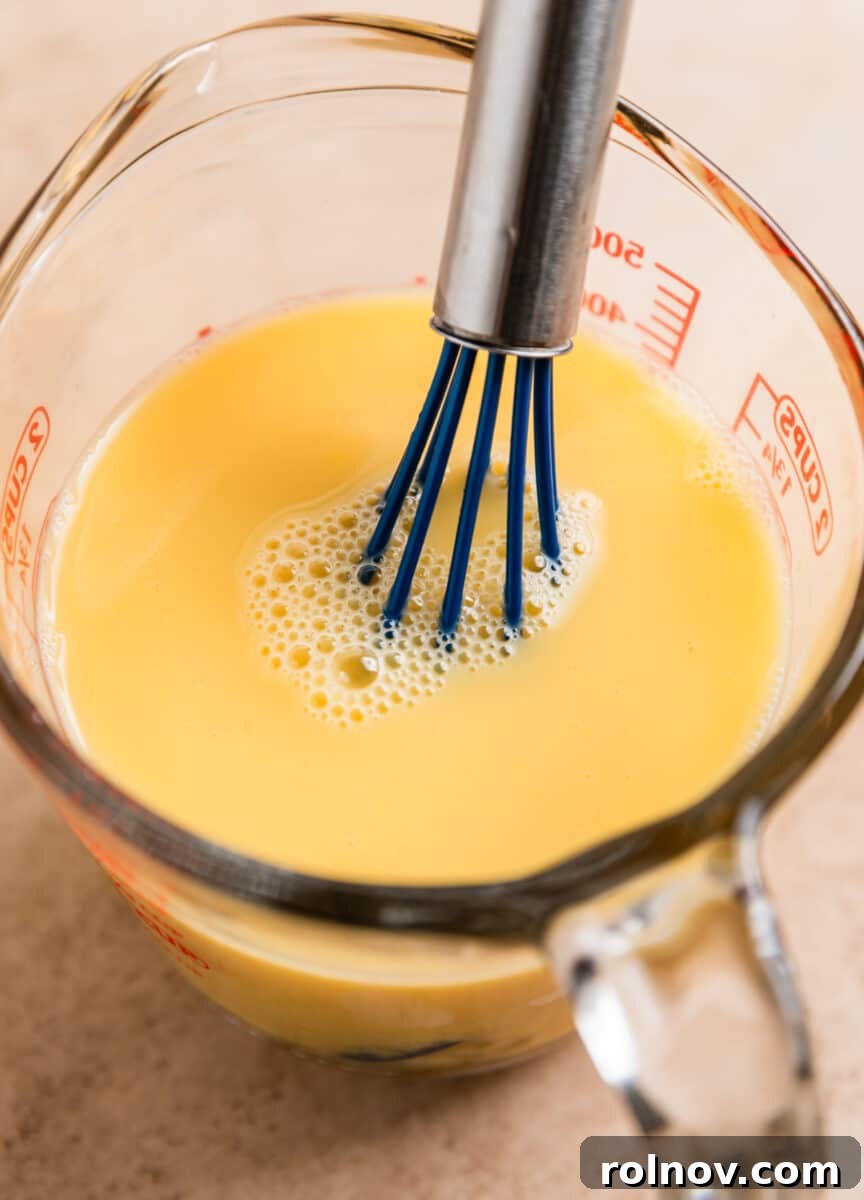 Classic Turkey Sausage Dressing 12 Egg and chicken broth whisked together in a glass measuring cup.