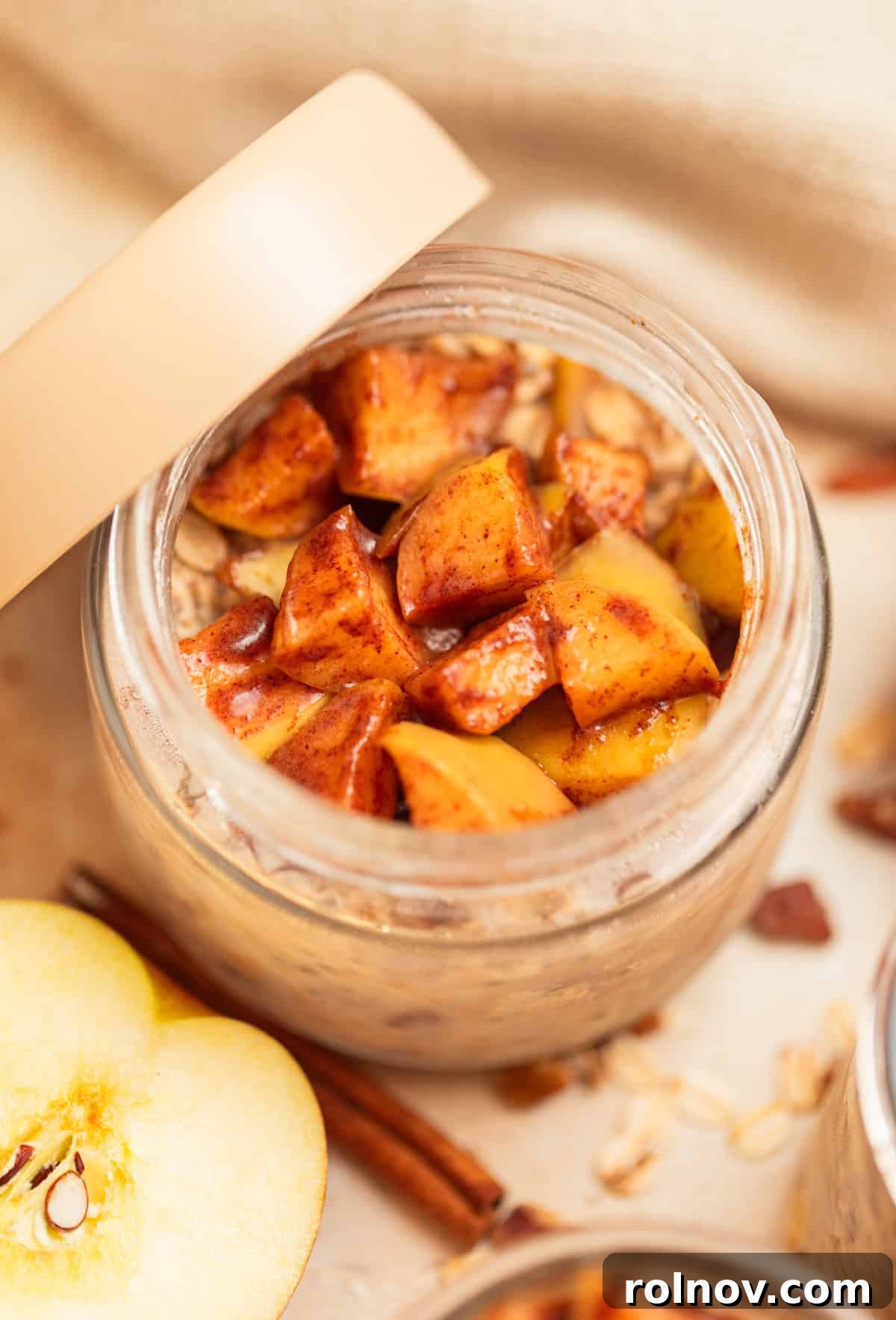 Apple Pie Overnight Oats 11 A single jar of apple cinnamon overnight oatmeal, with its lid propped gently against the side, ready to be enjoyed.