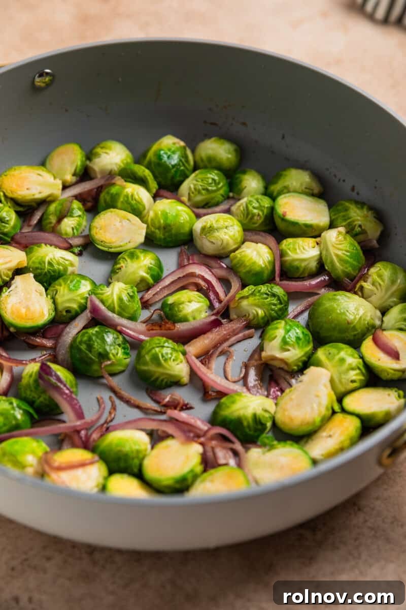 Sheet Pan Golden Chicken and Roasted Brussels Sprouts 6 Brussels sprouts and red onion sautéed in skillet.