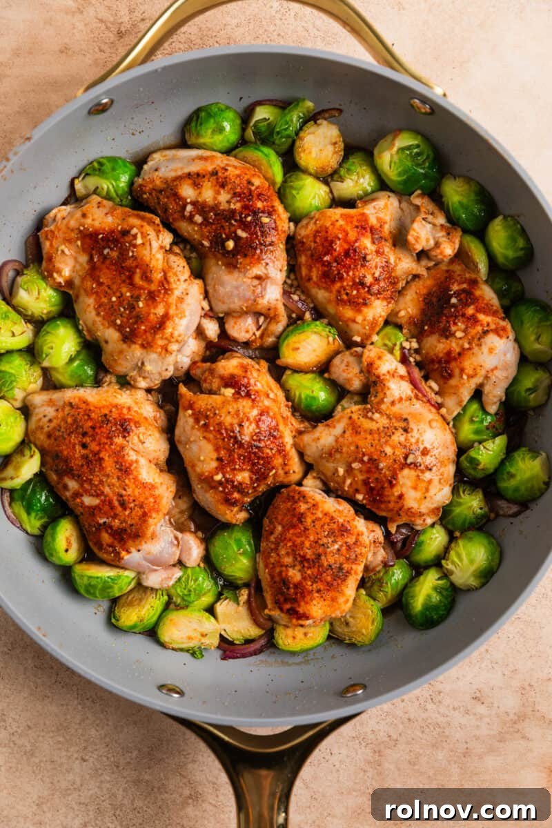 Sheet Pan Golden Chicken and Roasted Brussels Sprouts 8 Chicken and vegetables in skillet with balsamic vinegar, mixture poured over.