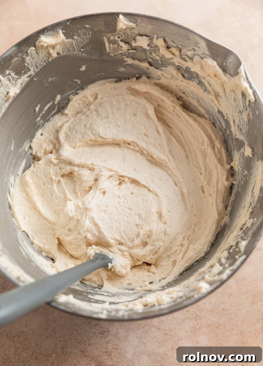 Ginger Cloud Cookies 16 Finished brown sugar buttercream frosting in mixing bowl with spatula.
