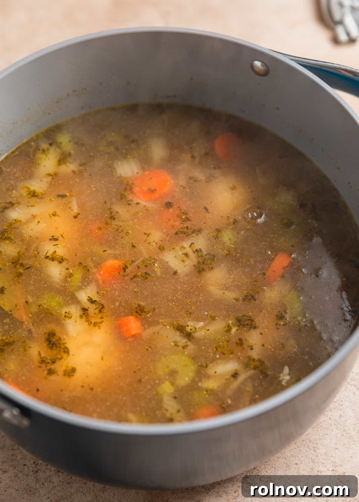 Zesty Lemon Chicken Orzo Soup 5 Perfectly cooked chicken pieces simmering gently in a flavorful broth, ready to be removed and shredded.