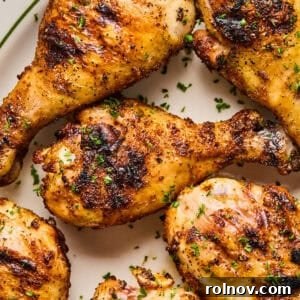 Grilled Chicken Drumsticks perfectly cooked and arranged on a white serving dish.