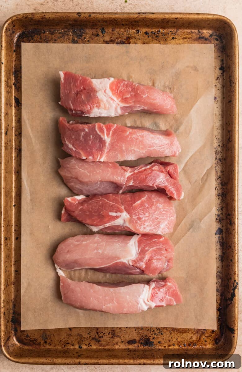 Crispy Air Fryer Country Ribs 5 Raw pork boneless ribs on parchment lined baking sheet.