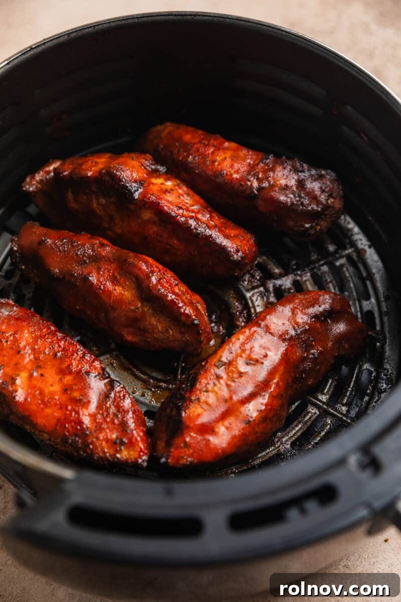 Crispy Air Fryer Country Ribs 9 Cooked boneless pork ribs in air fryer basket with barbecue sauce.