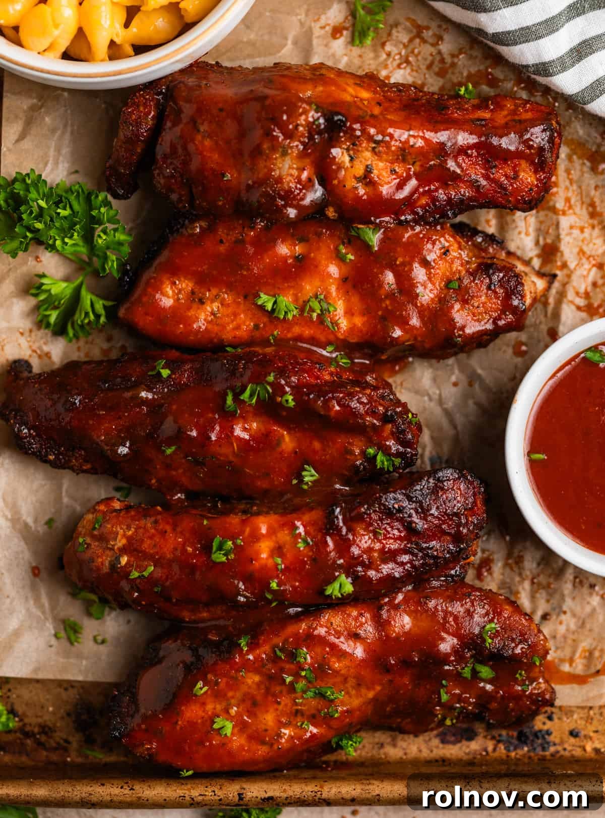 Crispy Air Fryer Country Ribs 10 BBQ country style ribs on parchment lined baking sheet with macaroni and cheese in dish.
