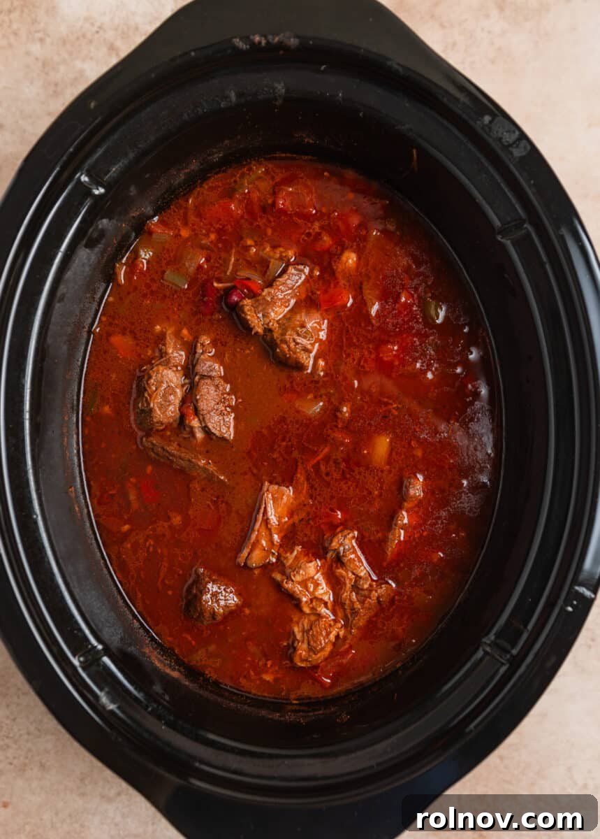 Slow Cooker Pulled Beef Chili 8 Cooked slow cooker chili, with large pieces of tender beef still intact before shredding.