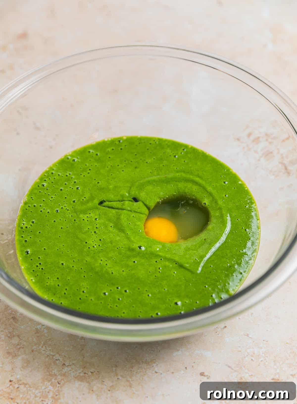Emerald Chocolate Muffins 6 Glass mixing bowl with spinach and banana mixture and egg added to it.