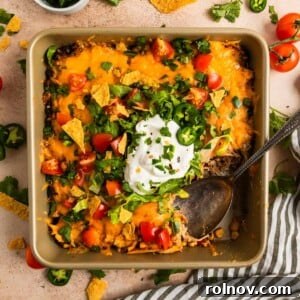 Chicken taco bake in pan with serving spoon scooping in.
