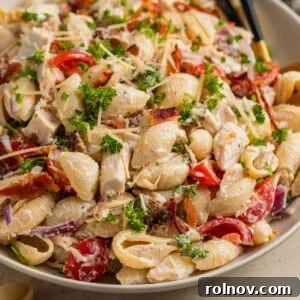 Dish with chicken bacon pasta salad and serving spoon.