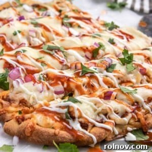 BBQ chicken flatbread with ranch and bbq sauce drizzle and fresh cilantro.