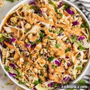 Ramen cabbage salad with peanut dressing over top in white bowl.