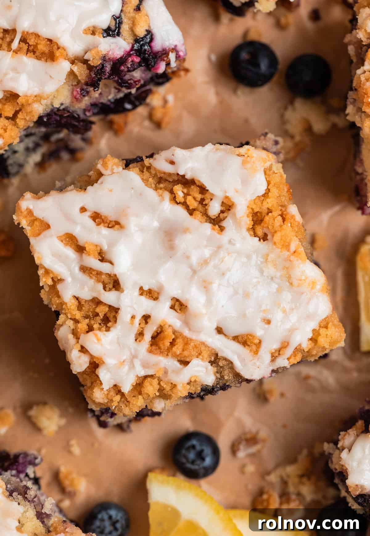Bright and Zesty Blueberry Lemon Coffee Cake 3 Top of slice of lemon blueberry coffee cake with crumb topping and icing.