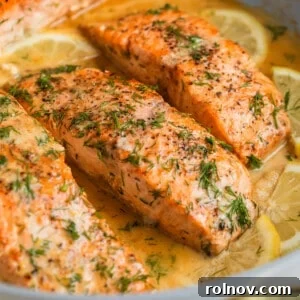 Zesty Lemon Dill Salmon 9 Lemon dill seared salmon in skillet with extra chopped dill on top and lemon slices.
