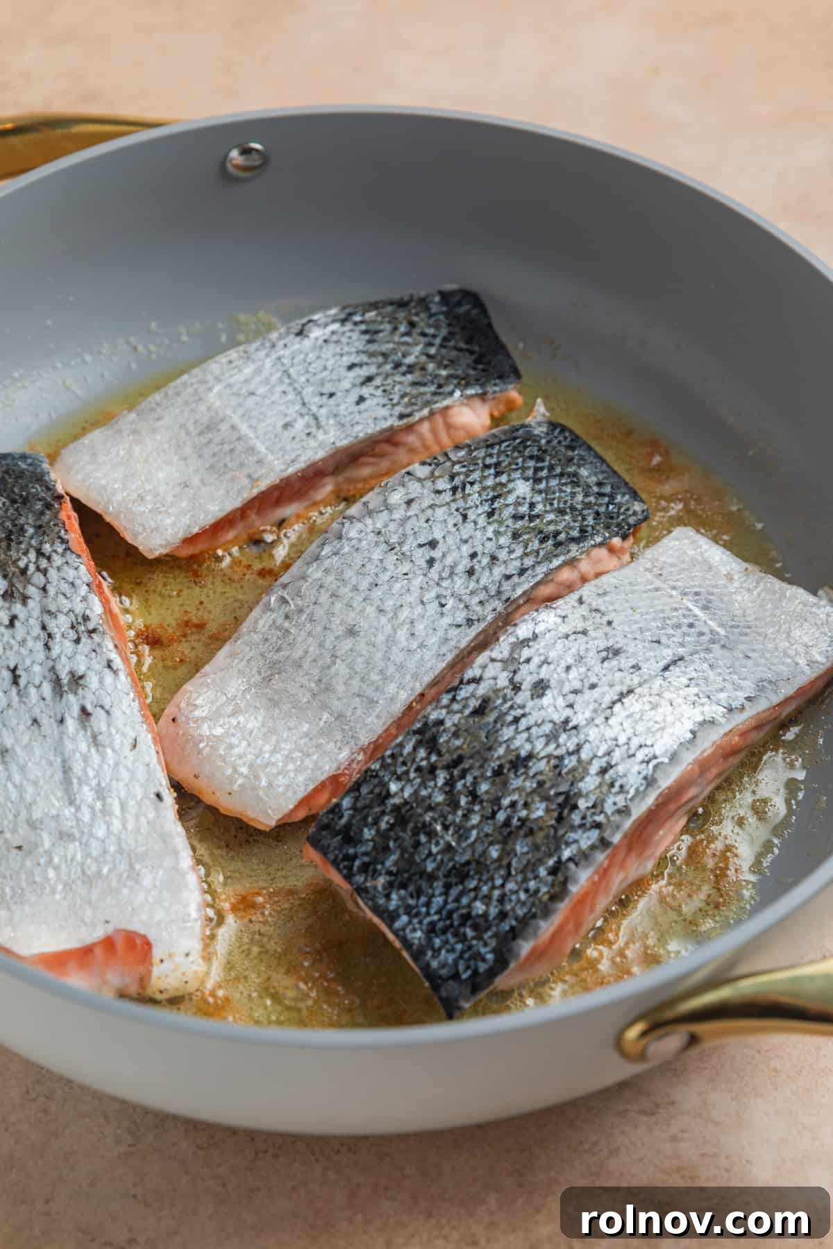 Zesty Lemon Dill Salmon 5 Salmon filets in skillet with skin up.
