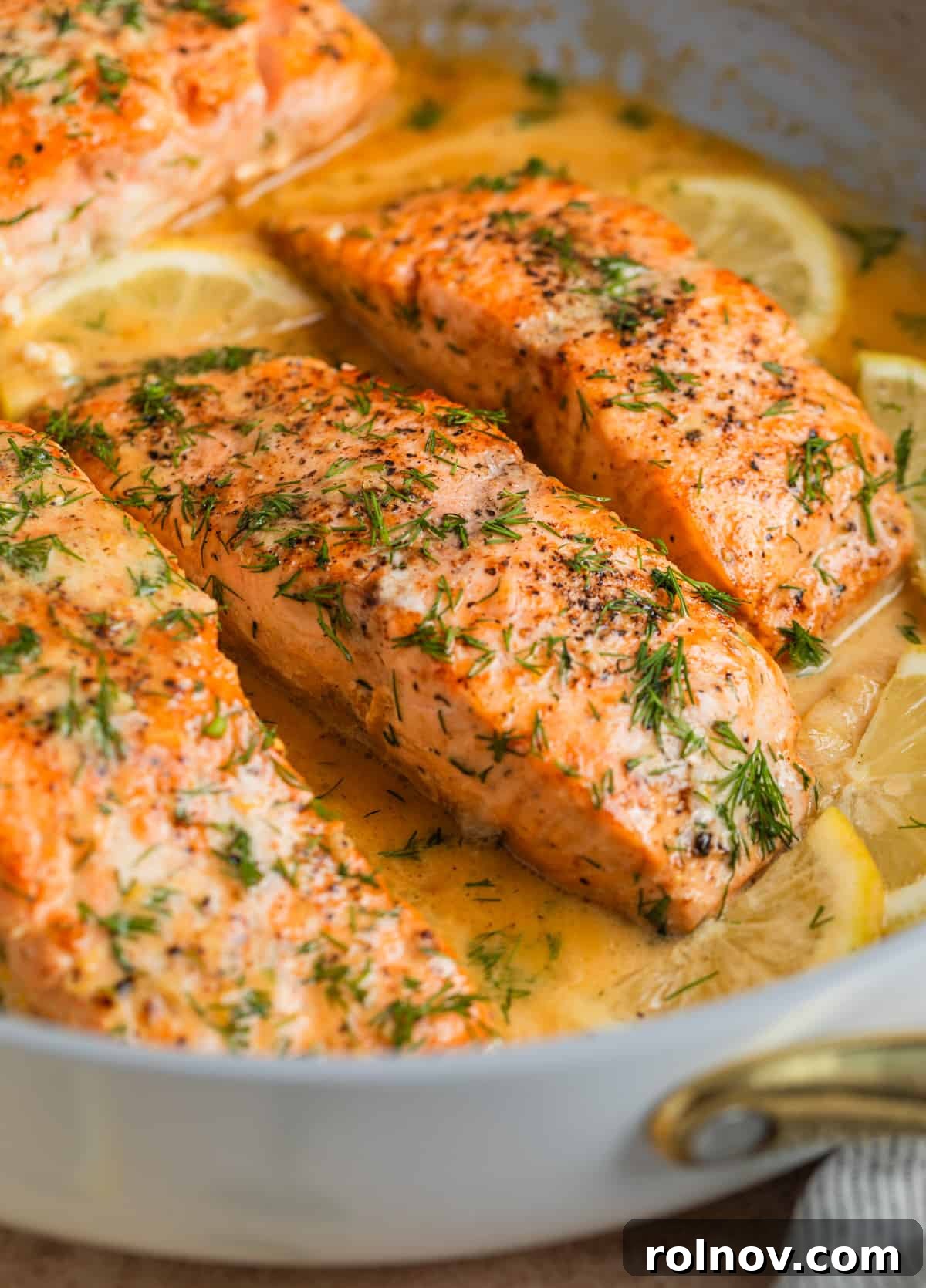 Zesty Lemon Dill Salmon 8 Salmon in skillet with lemons and topped with chopped dill.