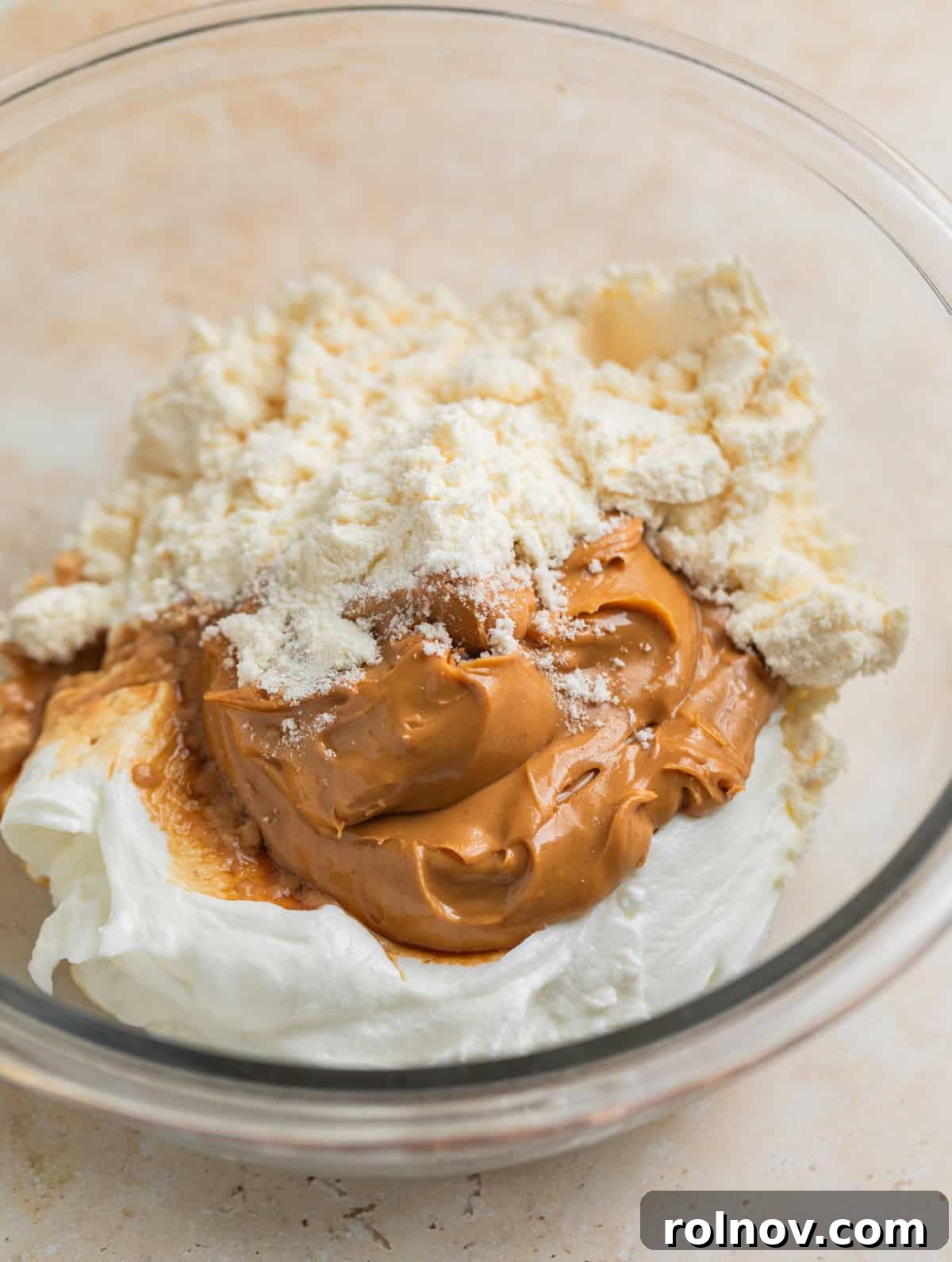 Frozen Greek Yogurt Bites 4 Peanut butter, plain Greek yogurt, protein powder and vanilla in glass mixing bowl, ready to be combined.